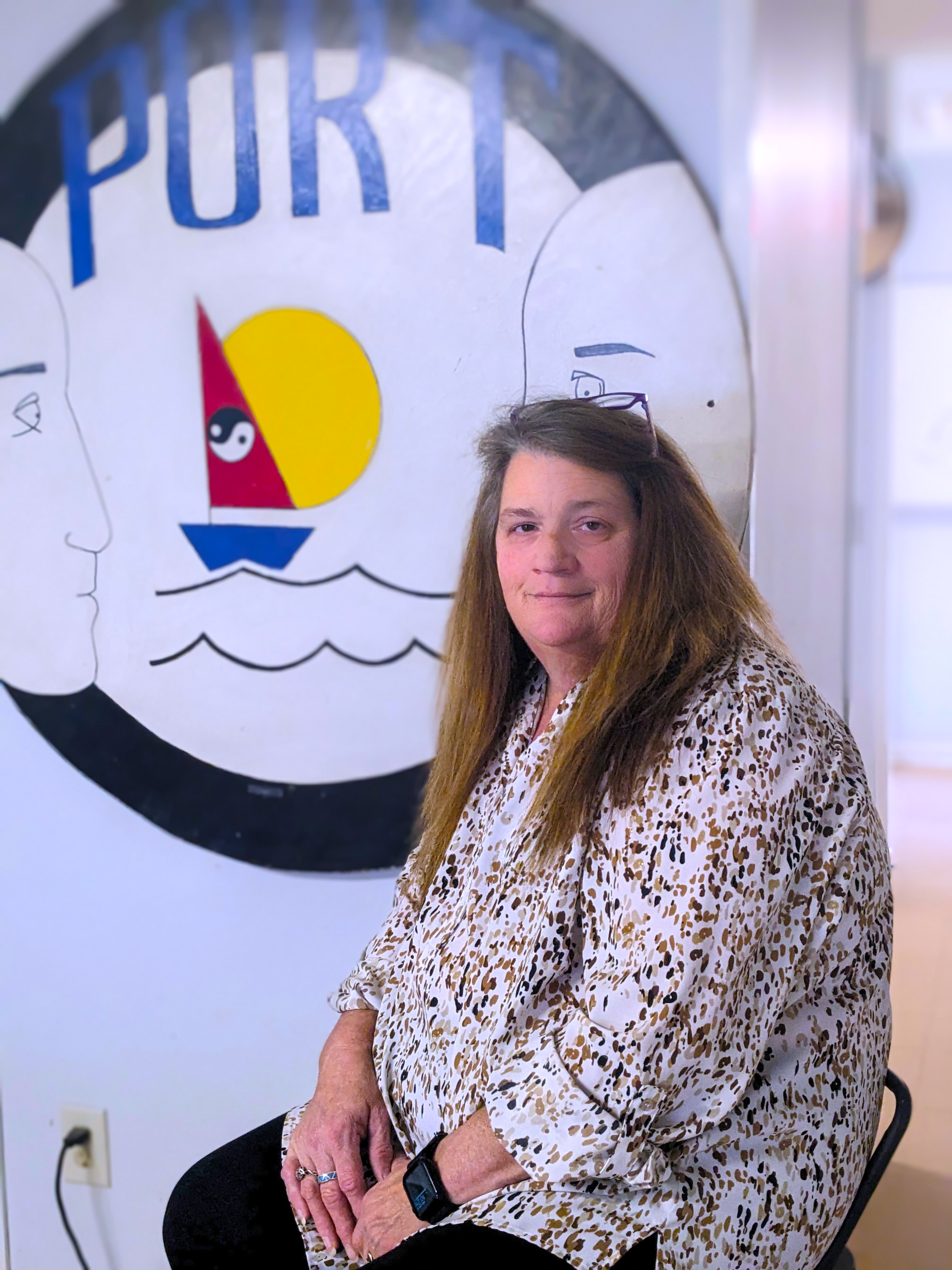 Cynthia Lassiter sits next to artwork for Port Health