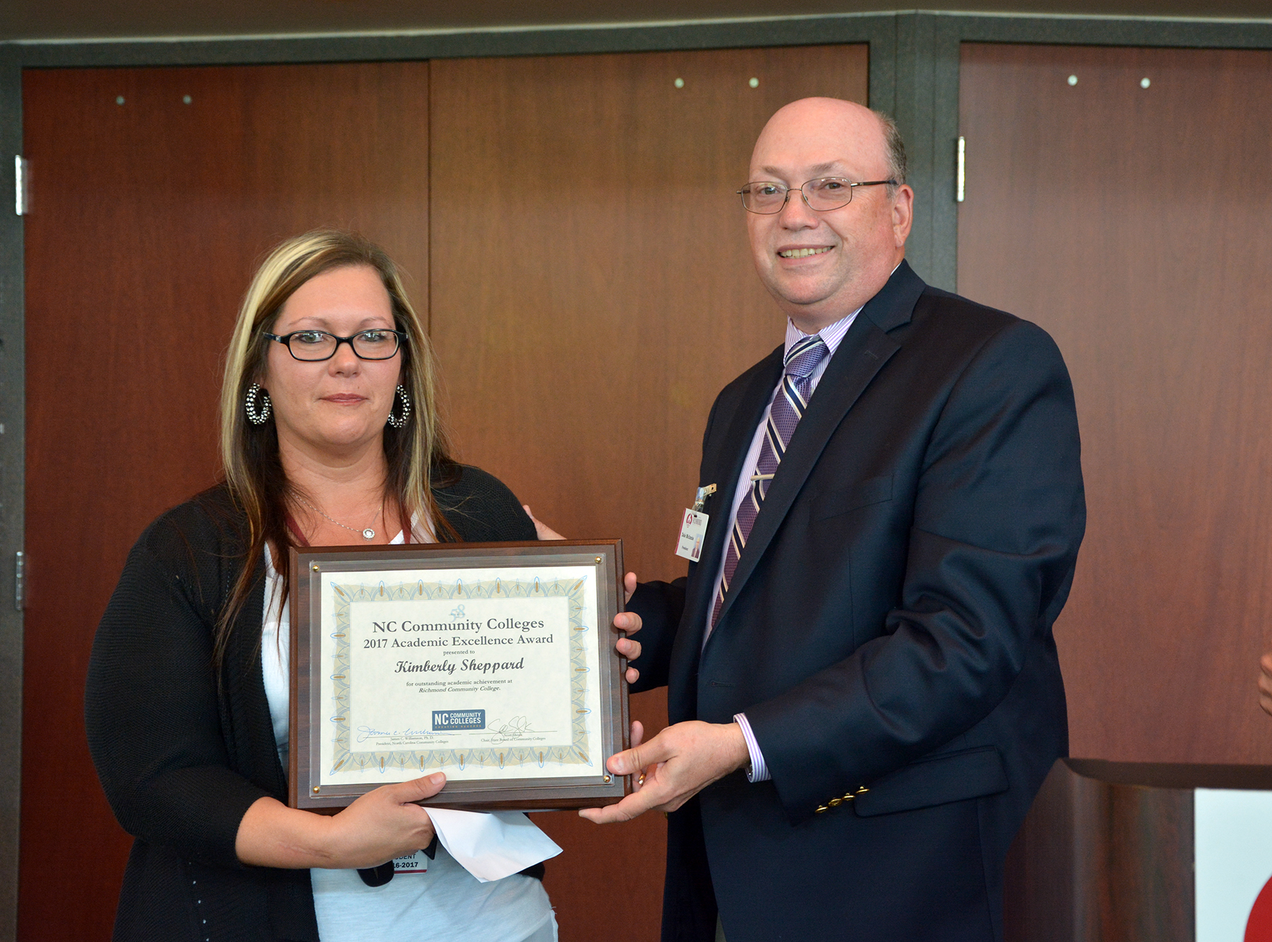 Kimberly Sheppard accepts an award from Dr. Dale McInnis