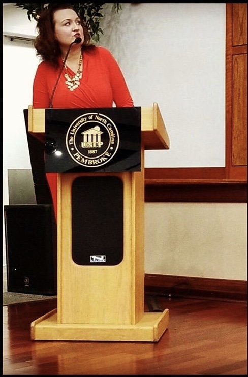 Human Services Technology instructor Amanda Faulk standing at a podium speaking at a conference