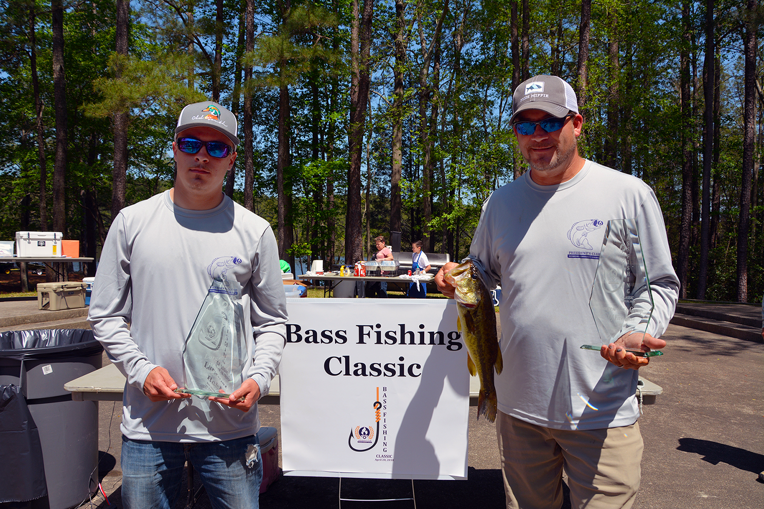 The winners of the Bass Fishing Classic hold their trophies and the winning fish.