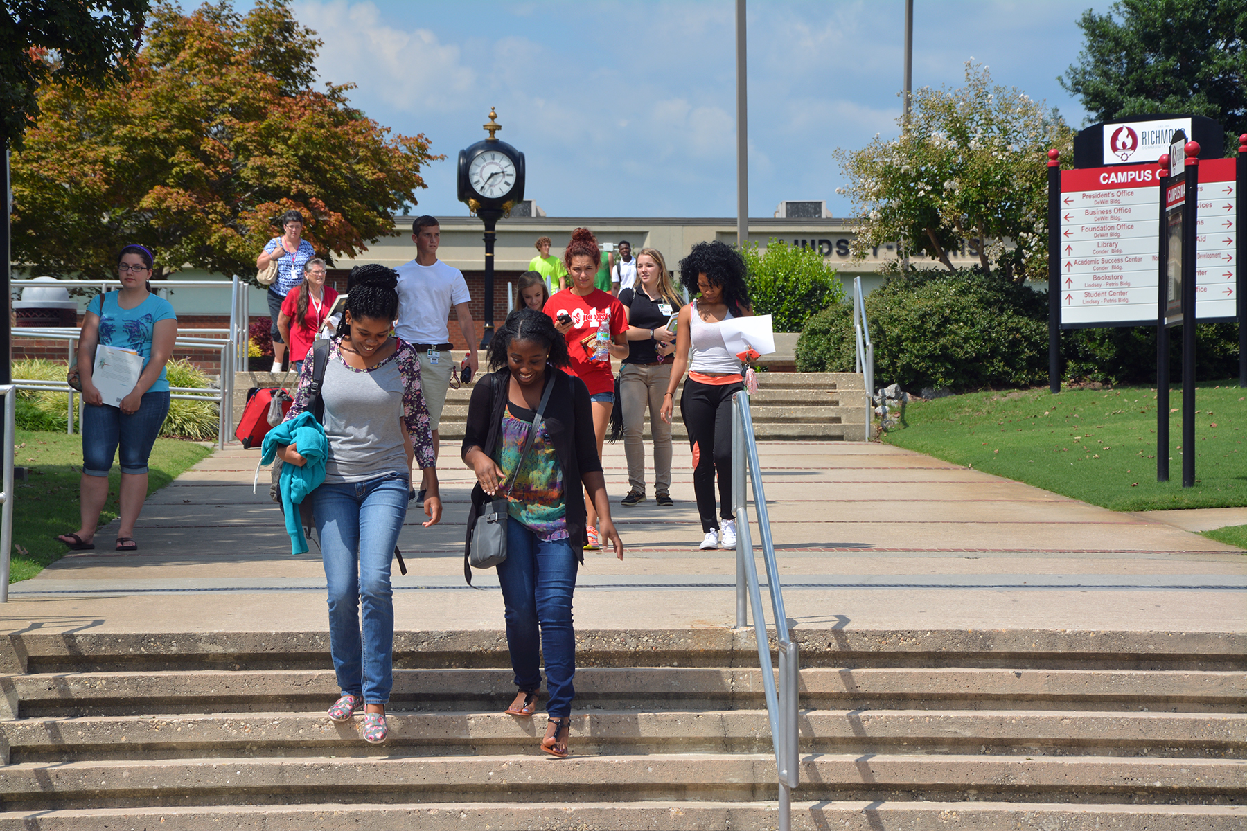 Students walking across campus with clock in background