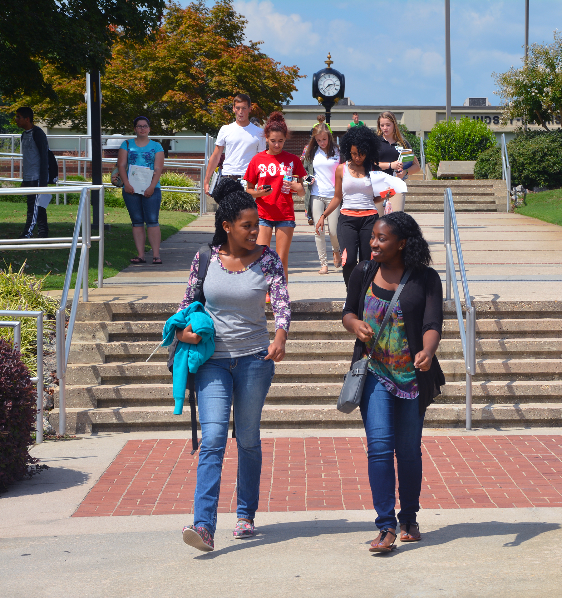 Career and College Promise high school students who are dually enrolled at Richmond Community College walk down stairs leading to the parking lot of the main campus.