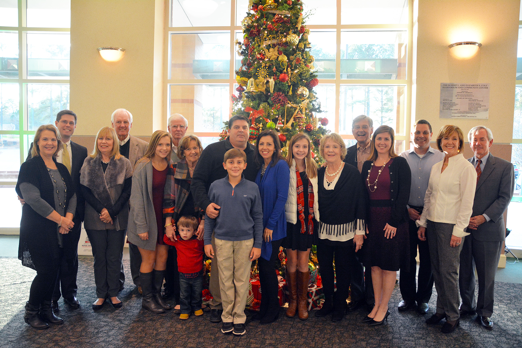 Family members of Chris Clark stand around the Christmas tree at the Cole Auditorium.