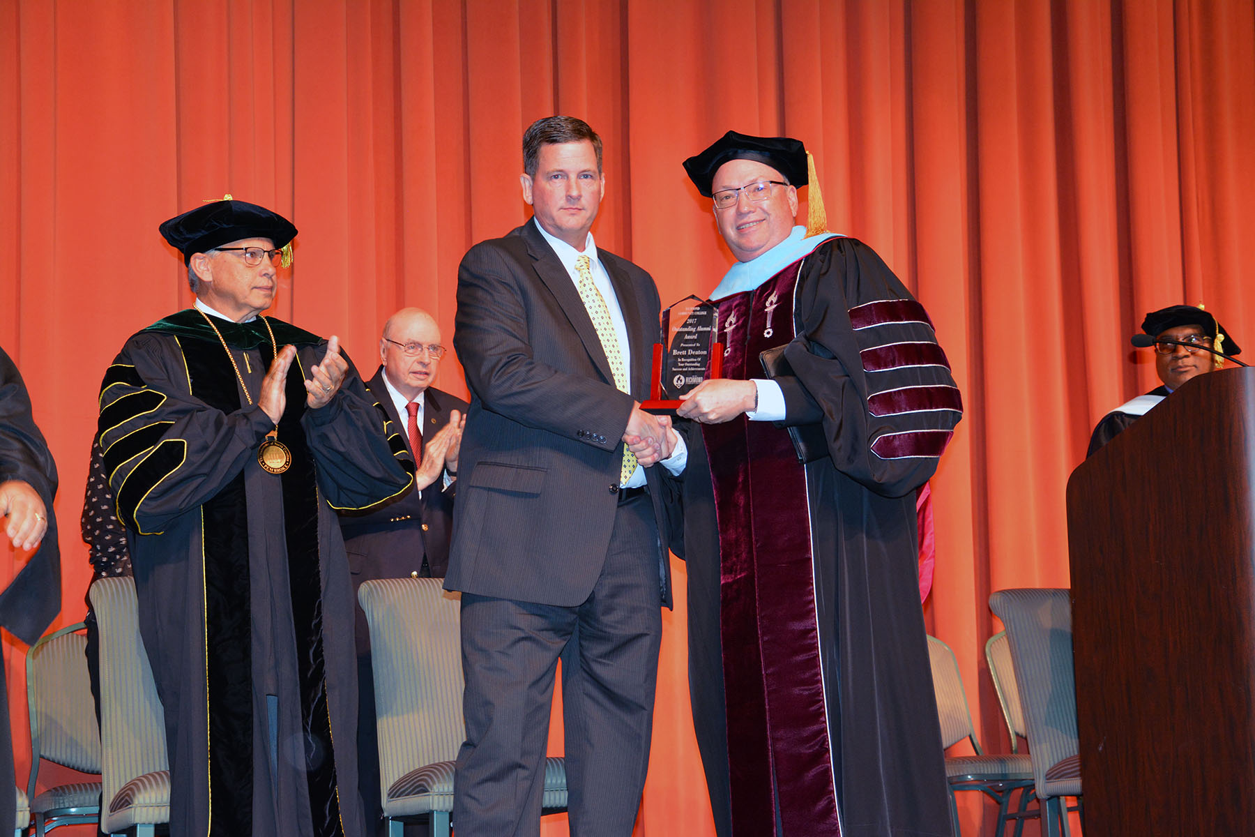 RichmondCC graduate Brett Deaton accepts the Outstanding Alumni Award from Dr. Dale McInnis