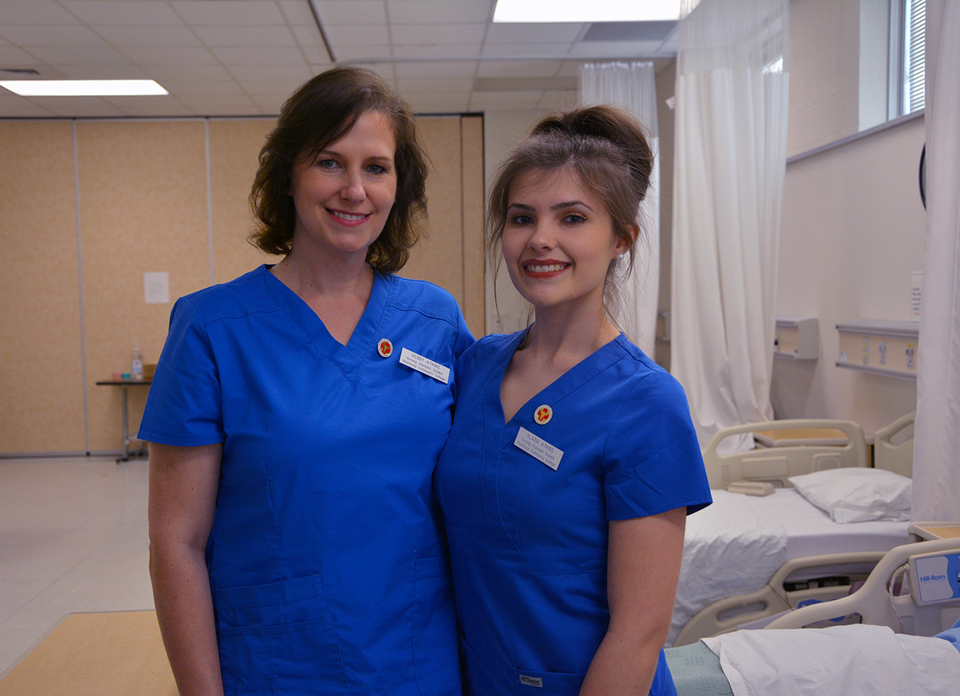 Debby Atkins and her daughter Alaina stand together in the nursing lab.