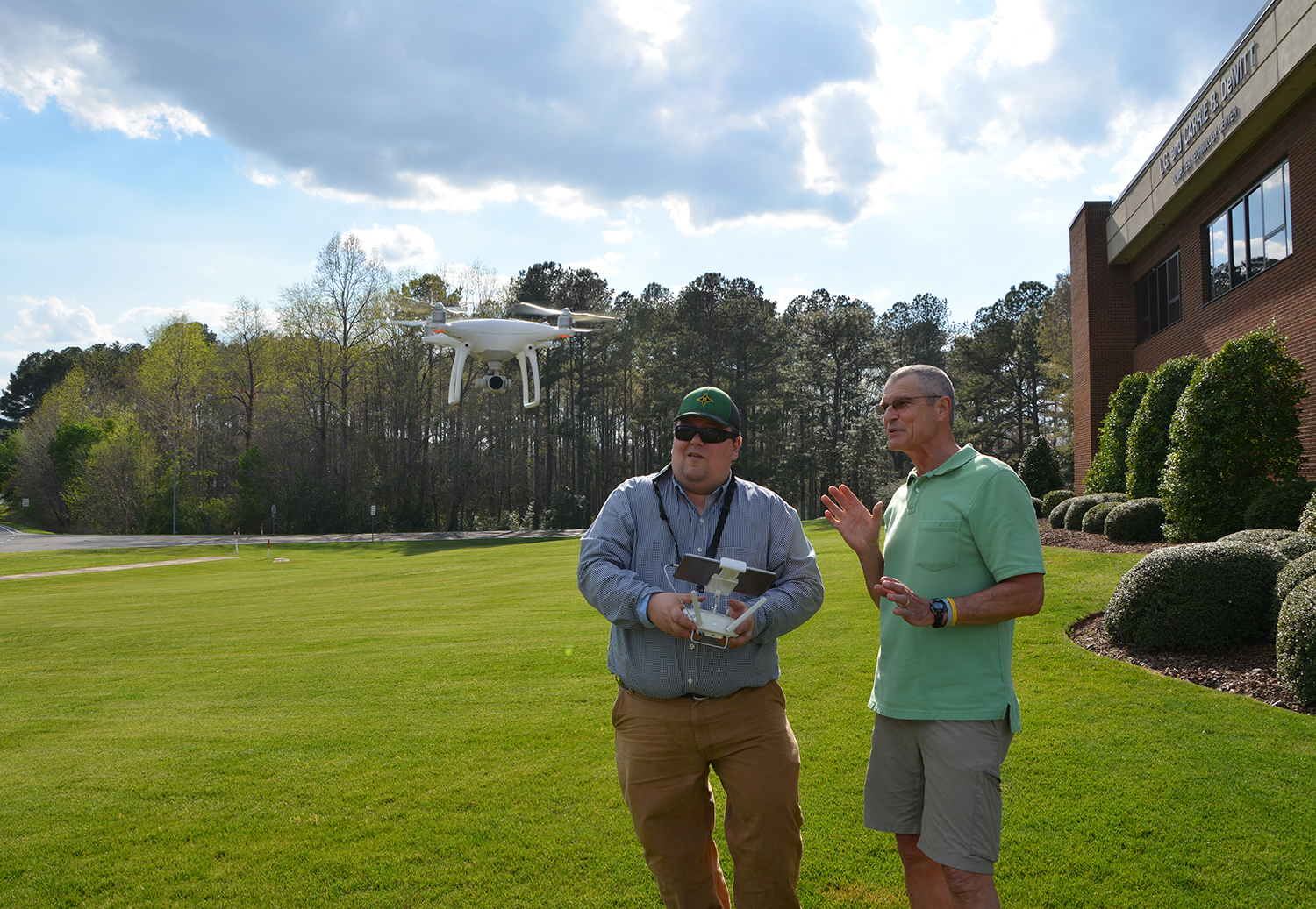 Drone instructor showing another man how to fly a drone