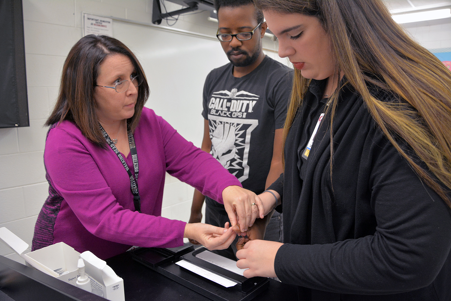 Criminal Justice instructor Robin Smith helping students with fingerprinting lesson