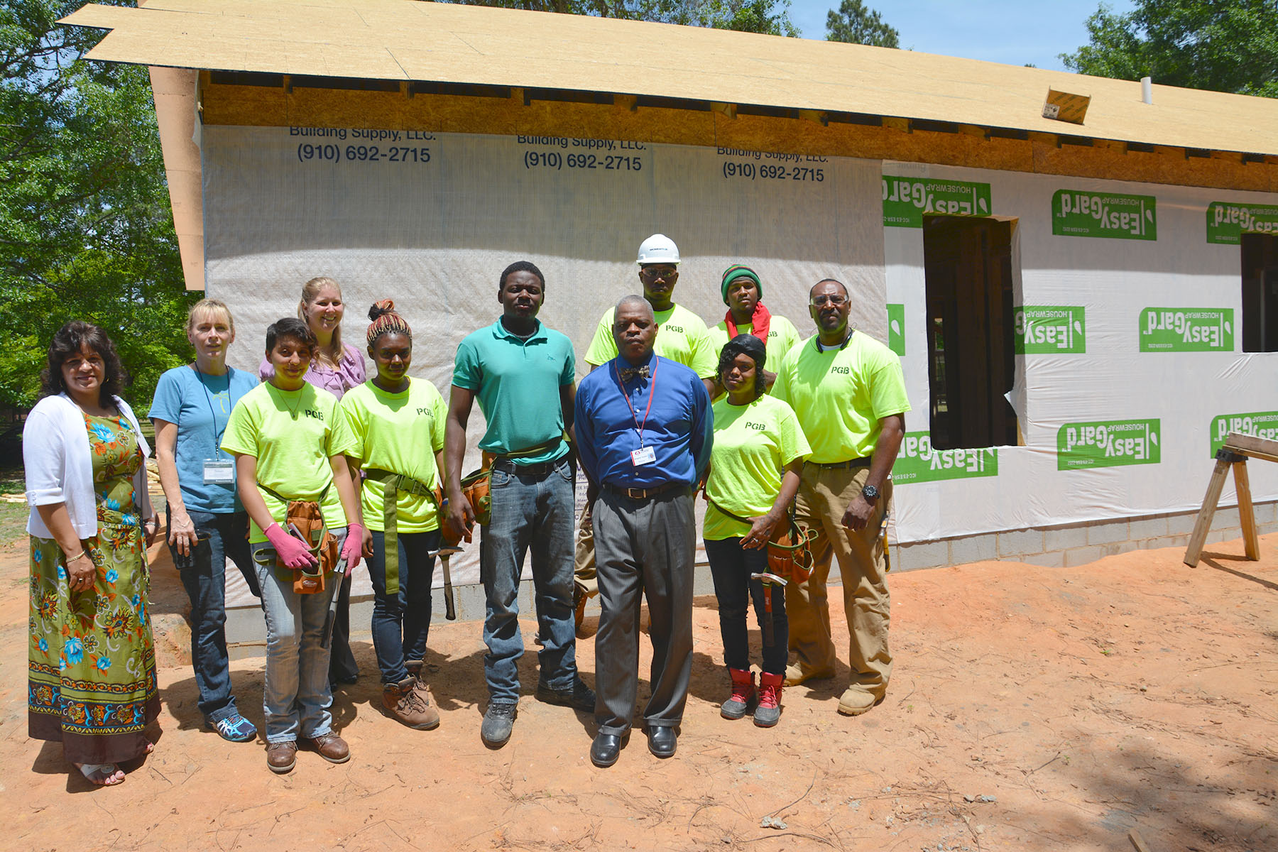 Terrence Wall, center, stands with his Washington Park classmates and instructors from a College and Career Readiness class at Richmond Community College outside a home the class is helping construct for Habitat for Humanity of Scotland County.