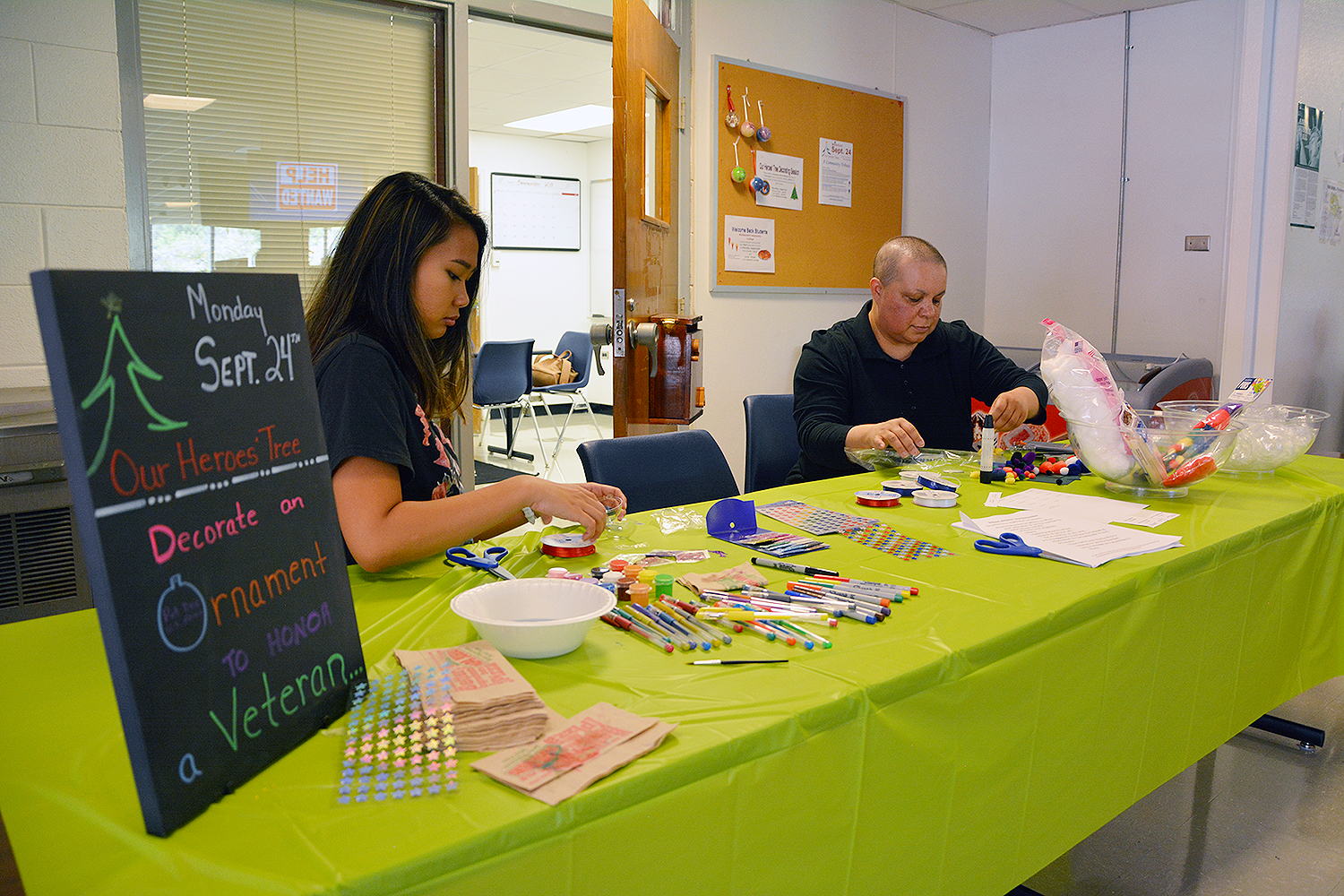 Two students work on ornaments for Our Heroes' Tree.