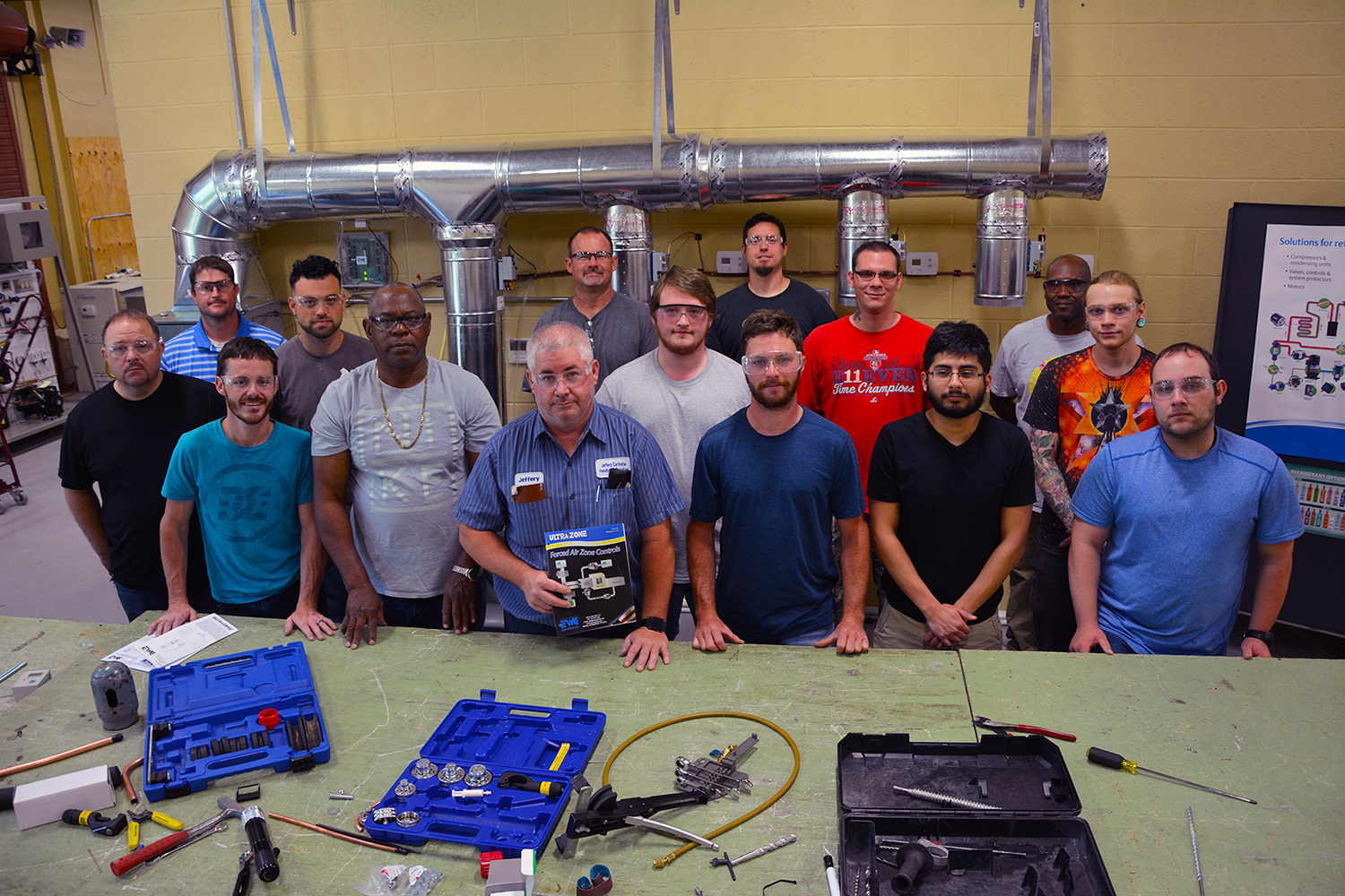 HVACR students stand in front of some equipment in the lab