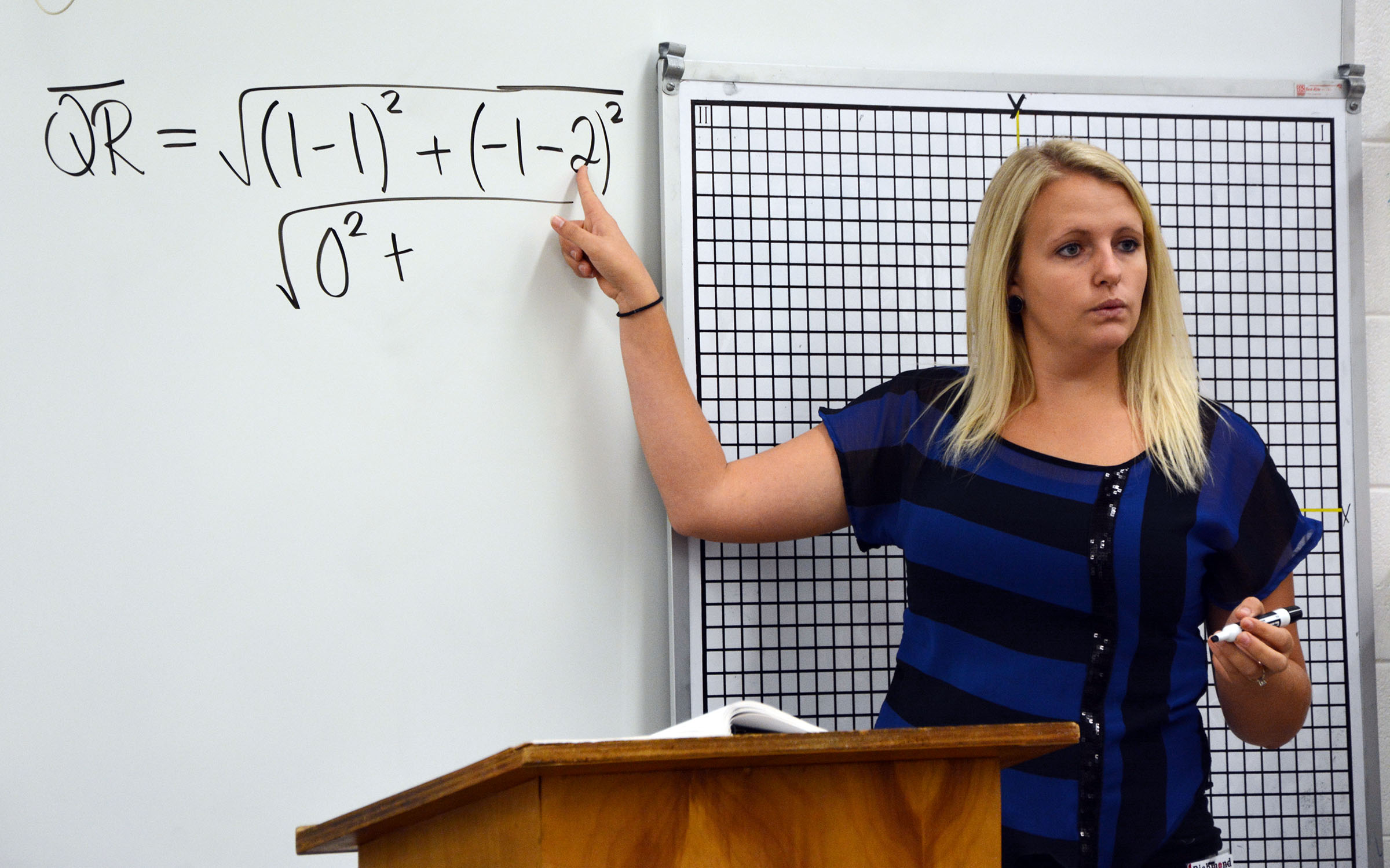 Instructor Holli Brown goes over a math equation on a white board.