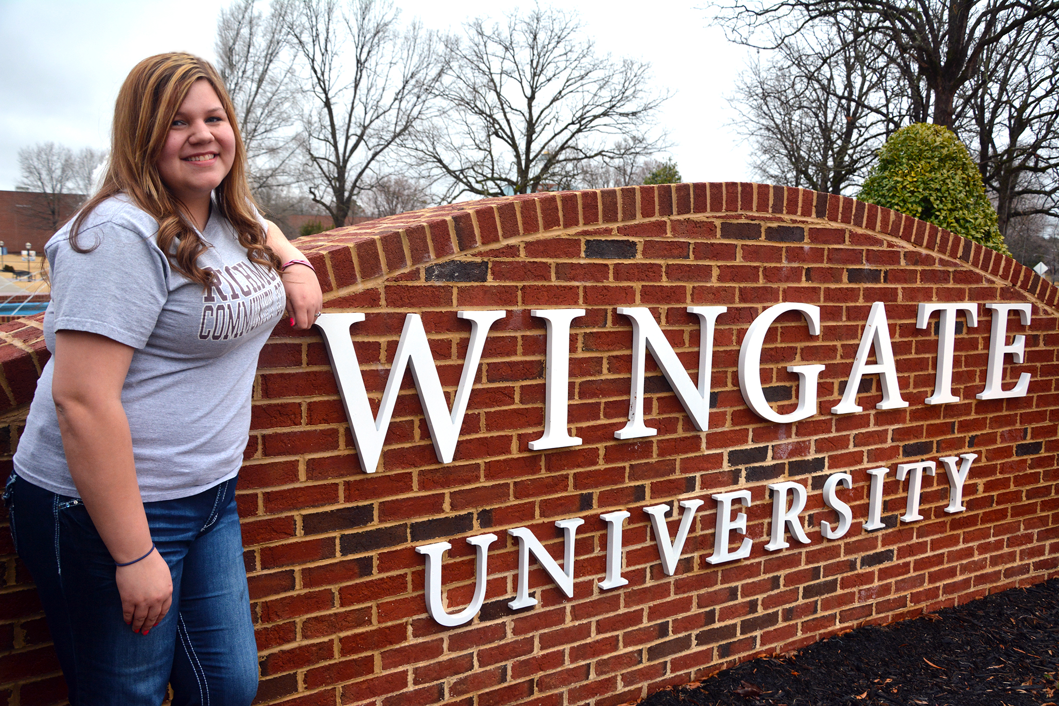 Lisa Hogan, Early College graduate from RCC, stands at the entrance of Wingate University where she is now a nursing student.