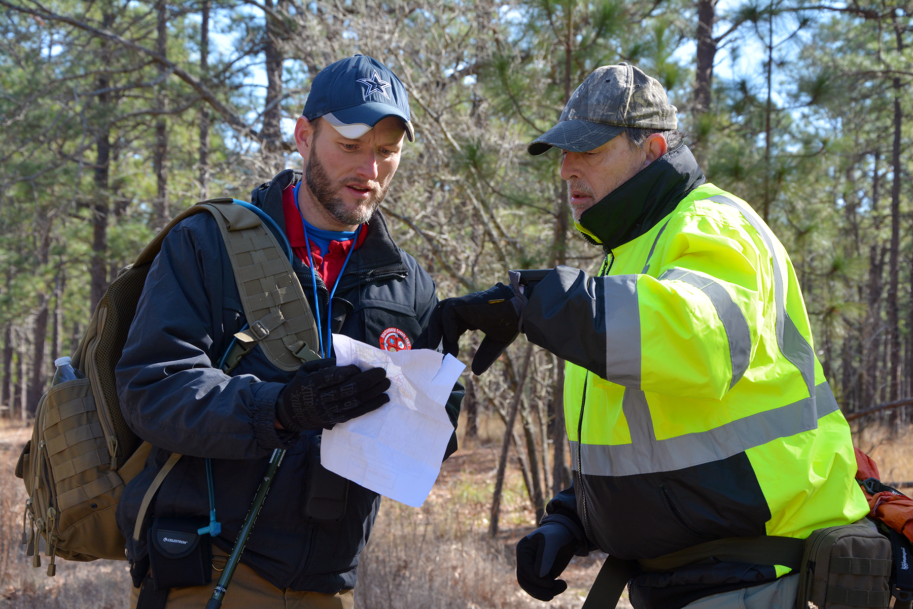 Two members of a search and rescue team look at a map of the operational area