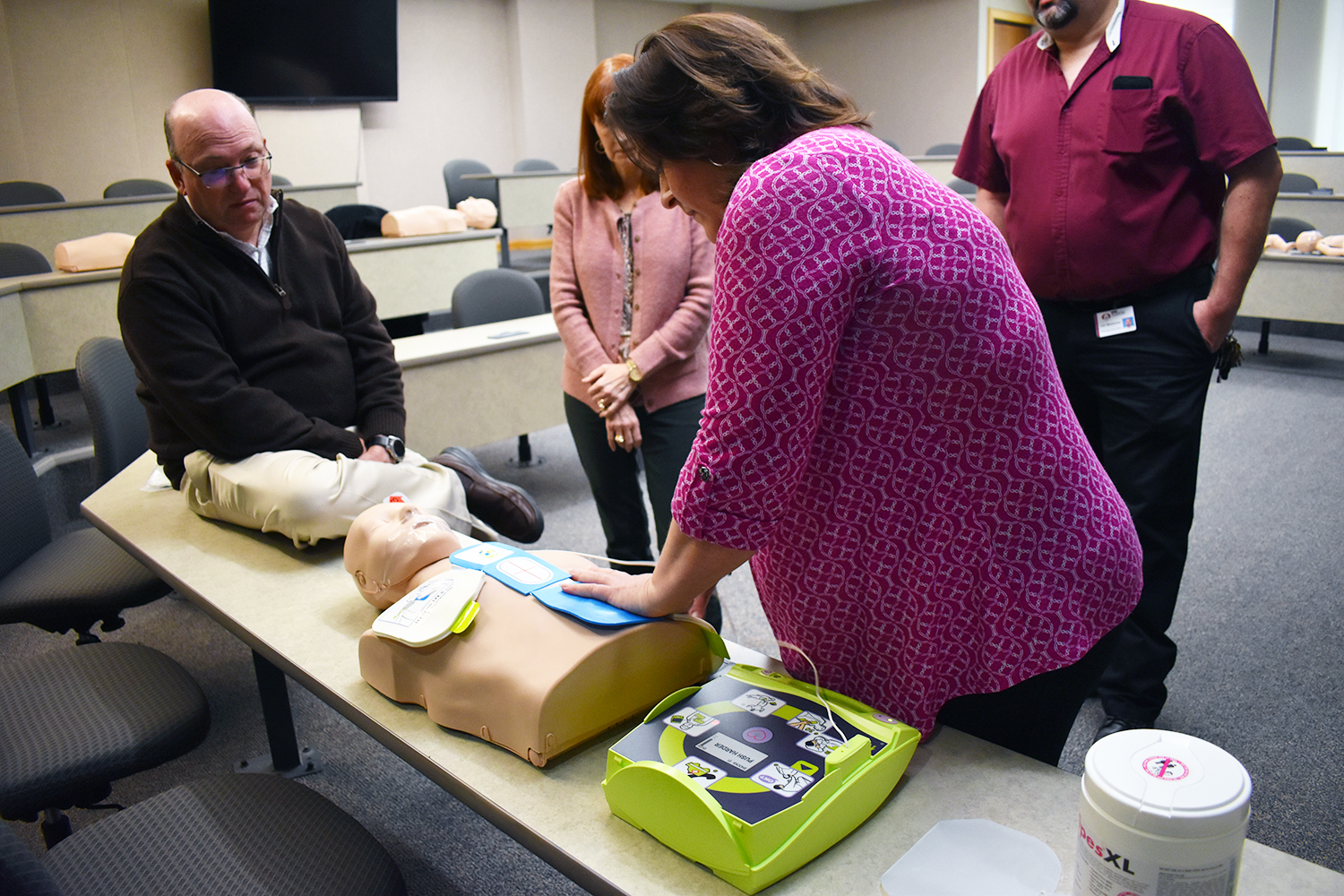 CPR instructor shows how to lay the pads of the AED device on the chest of someone experiencing cardiac arrest.