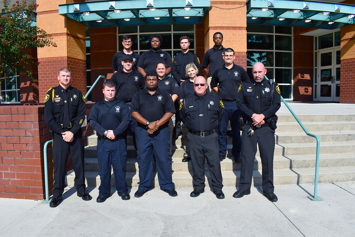 Class of 2020 Detention Officer Certification graduates stand with instructors on the steps of the Cole Auditorium