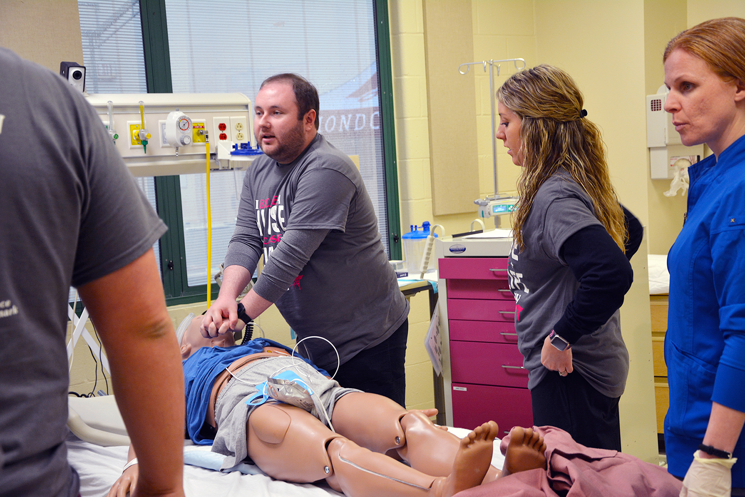 Nursing student performs chest compressions on a mannequin.