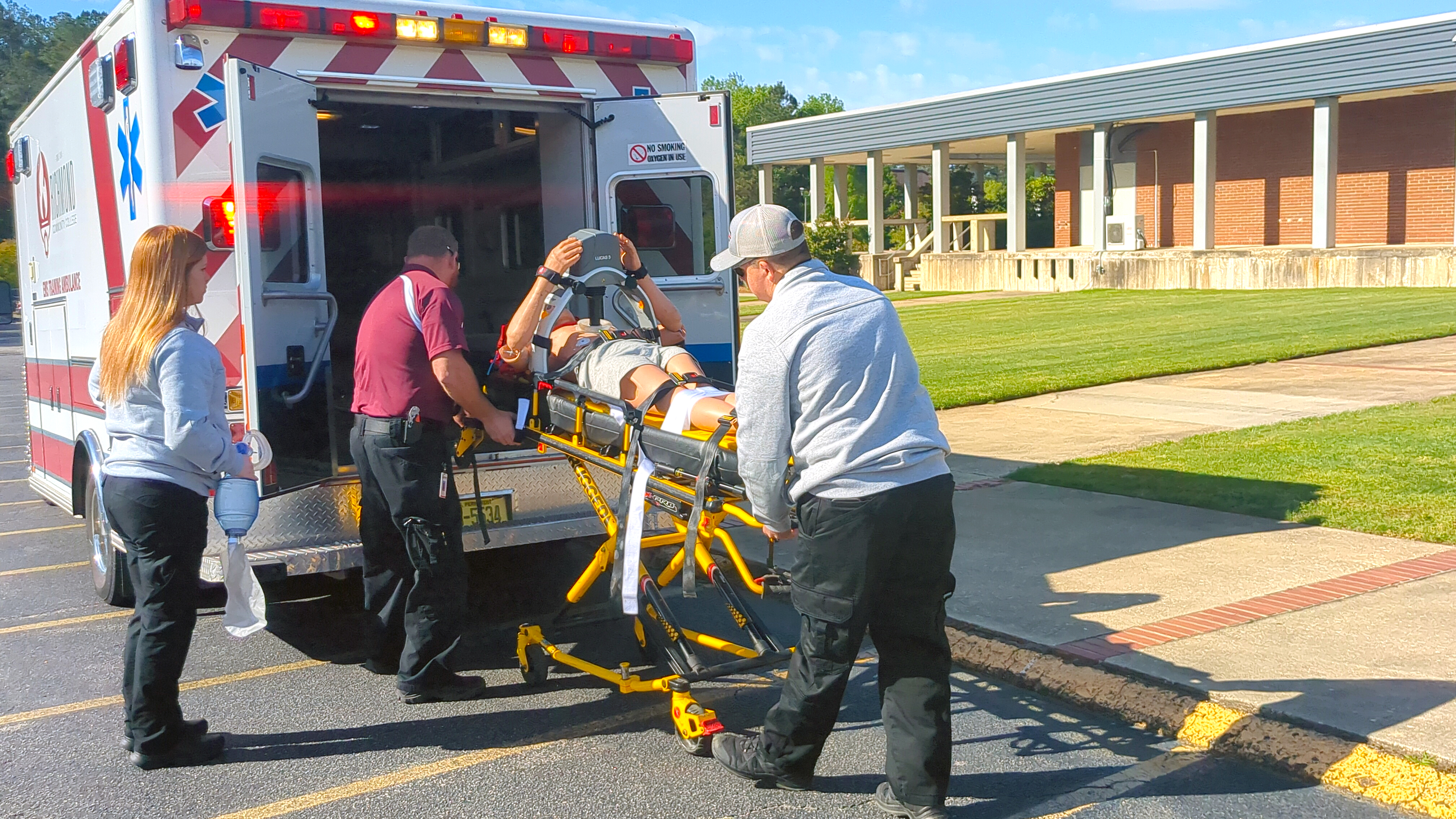 Students loading patient into ambulance