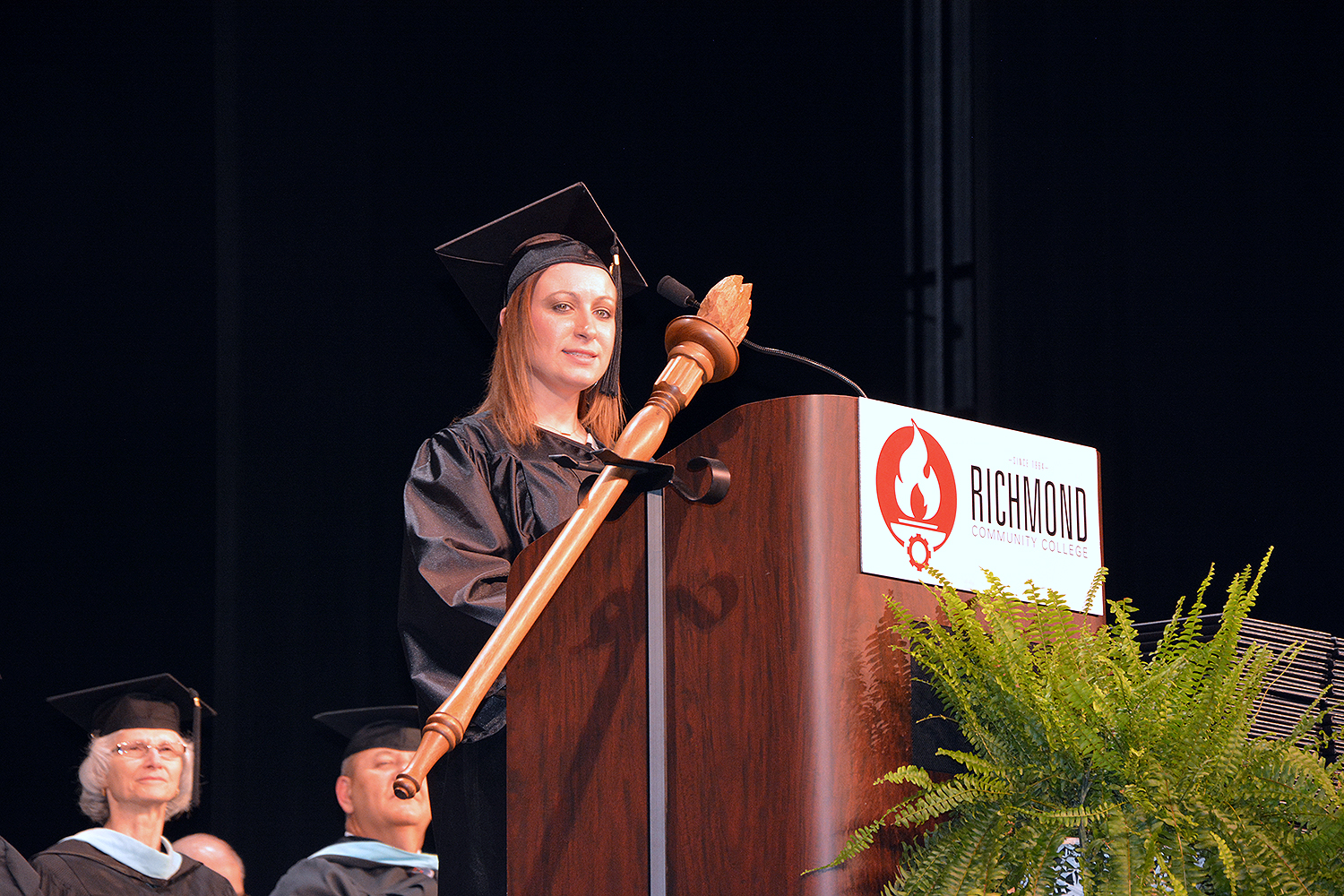 SGA President Nicole Williams stands a podium on stage at graduation