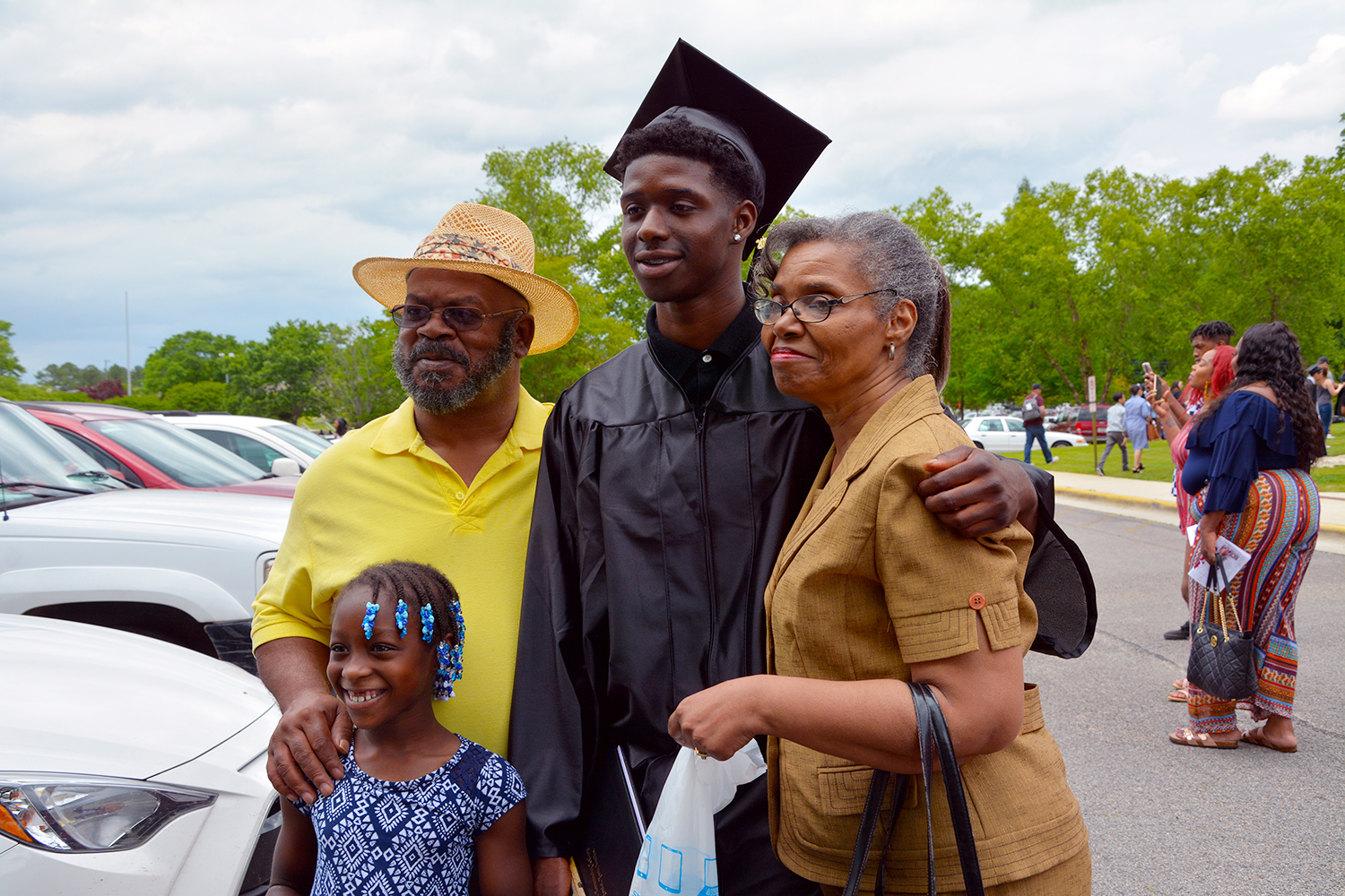 Graduate stands with his family for a photo