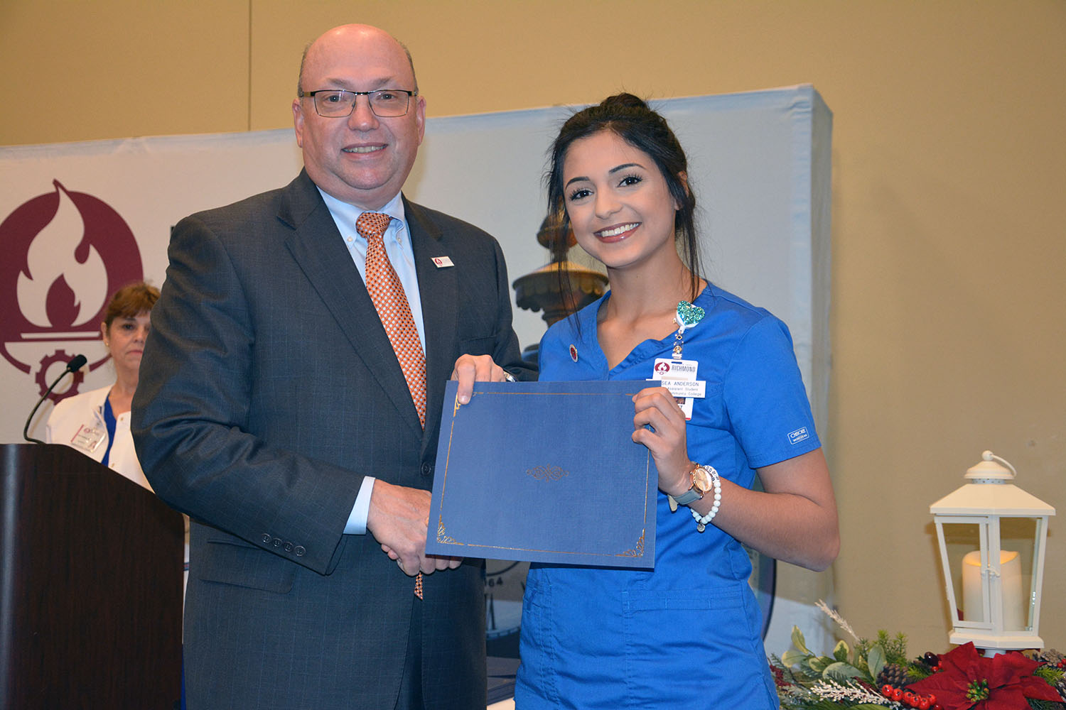 Richmond Community College nursing assistant student, Kelsea Anderson of Hamlet shakes hand with Dr. Dale McInnis, president of the College, during the pinning ceremony help for students completing the program.