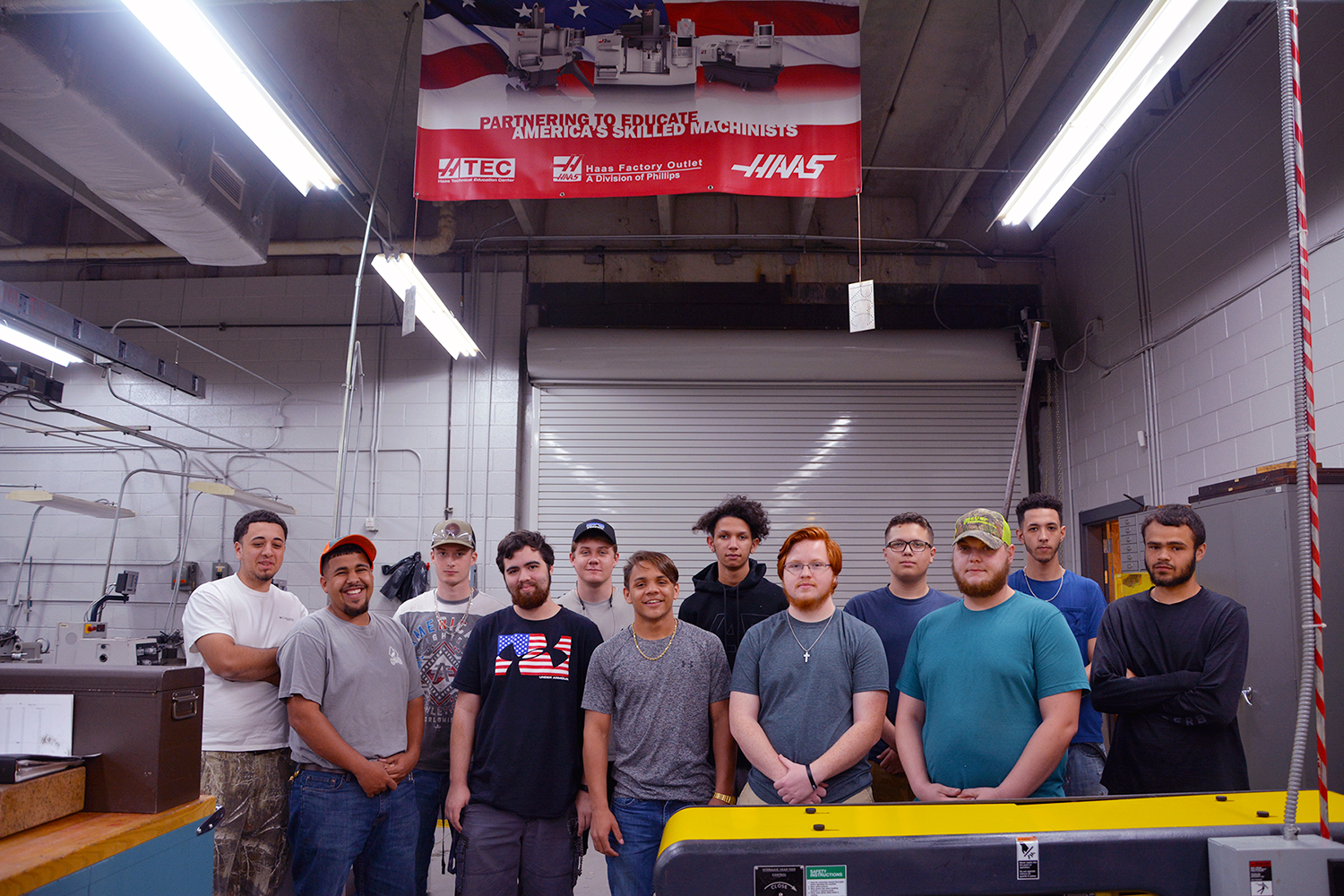 Machining students stand in a group in the machine shop