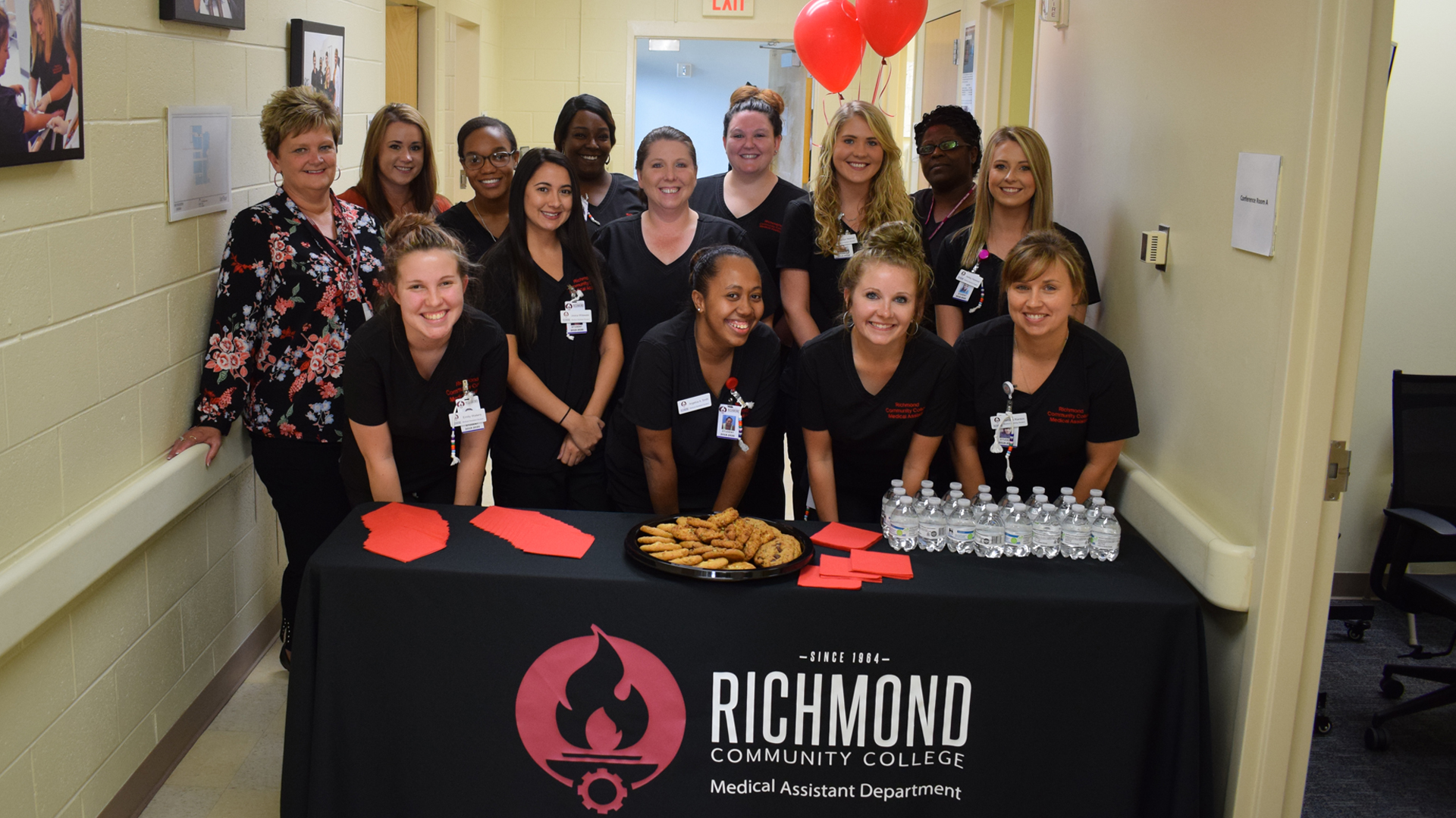 Medical Assisting students stand with instructors in the Simulation Learning Center.