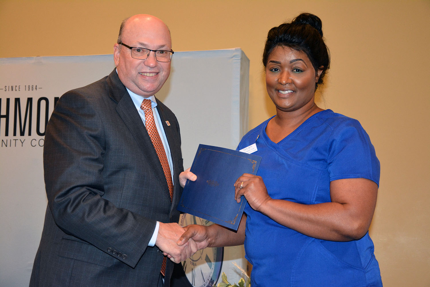 Richmond Community College nursing assistant student, Tonya Smith of Laurel Hill shakes hand with Dr. Dale McInnis, president of the College, during the pinning ceremony held for students completing the program.