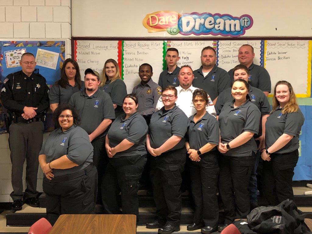 Students who completed the Emergency Medical Technician program pose for a photo in a classroom.