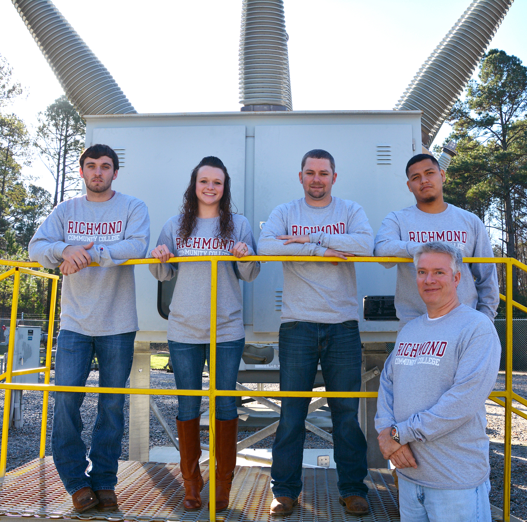 Members of the Fluke Connect team standing by transformer in substation