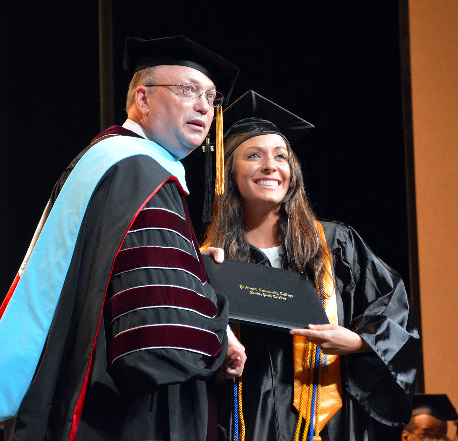 Dr. Dale McInnis handing Mary Lampley her diploma