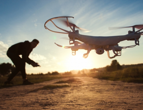 man flying drone at sunset