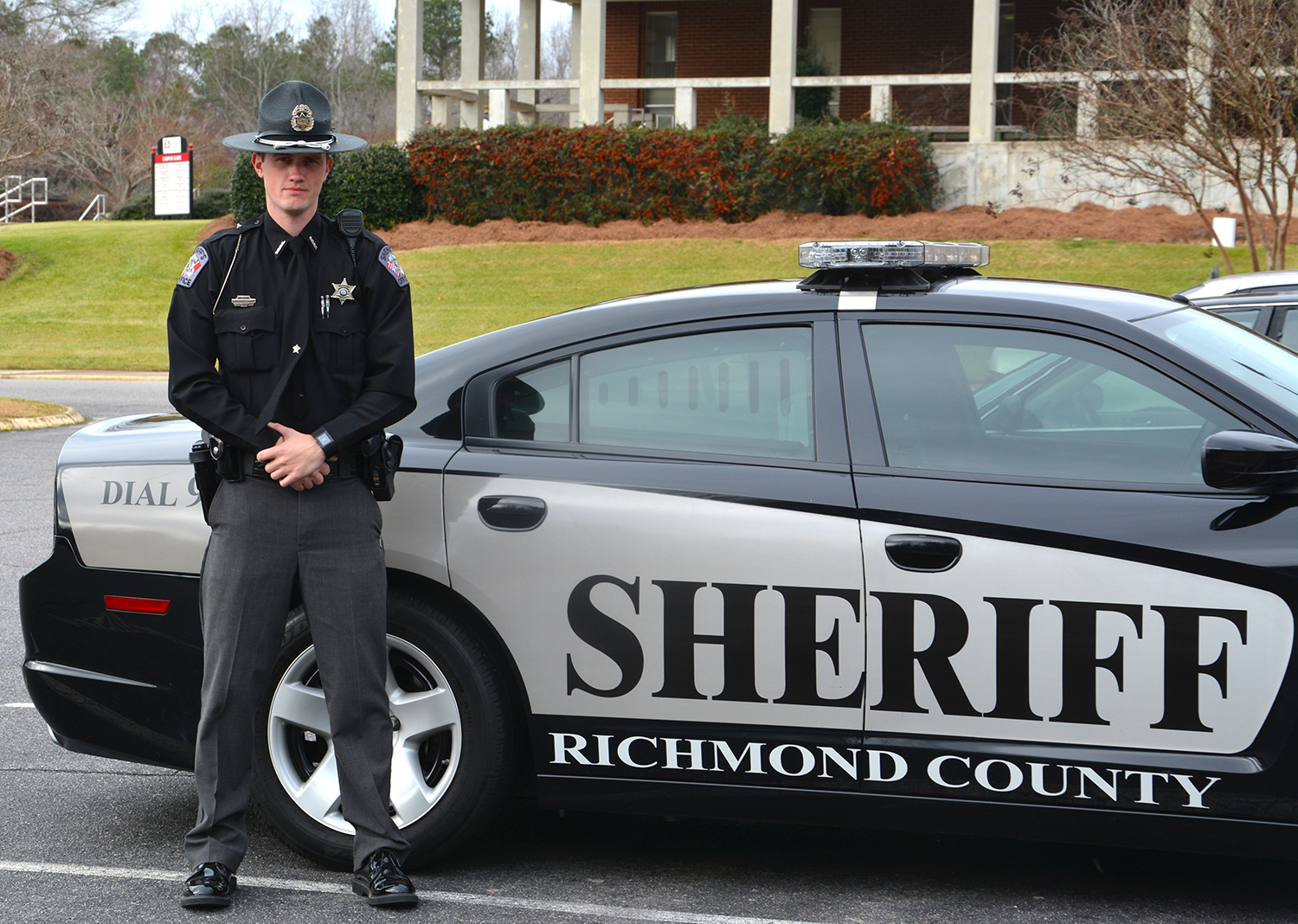 Richmond County Sheriff’s Deputy Thomas Thompson stands next to his patrol car on the campus of Richmond Community College, where he completed the Basic Law Enforcement Training program.
