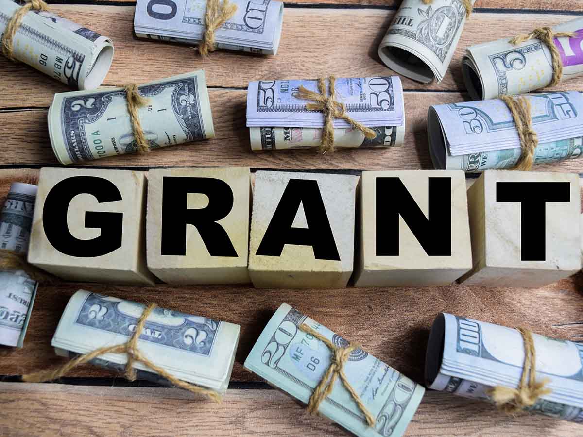 Blocks with GRANT written on them surrounded by rolled money