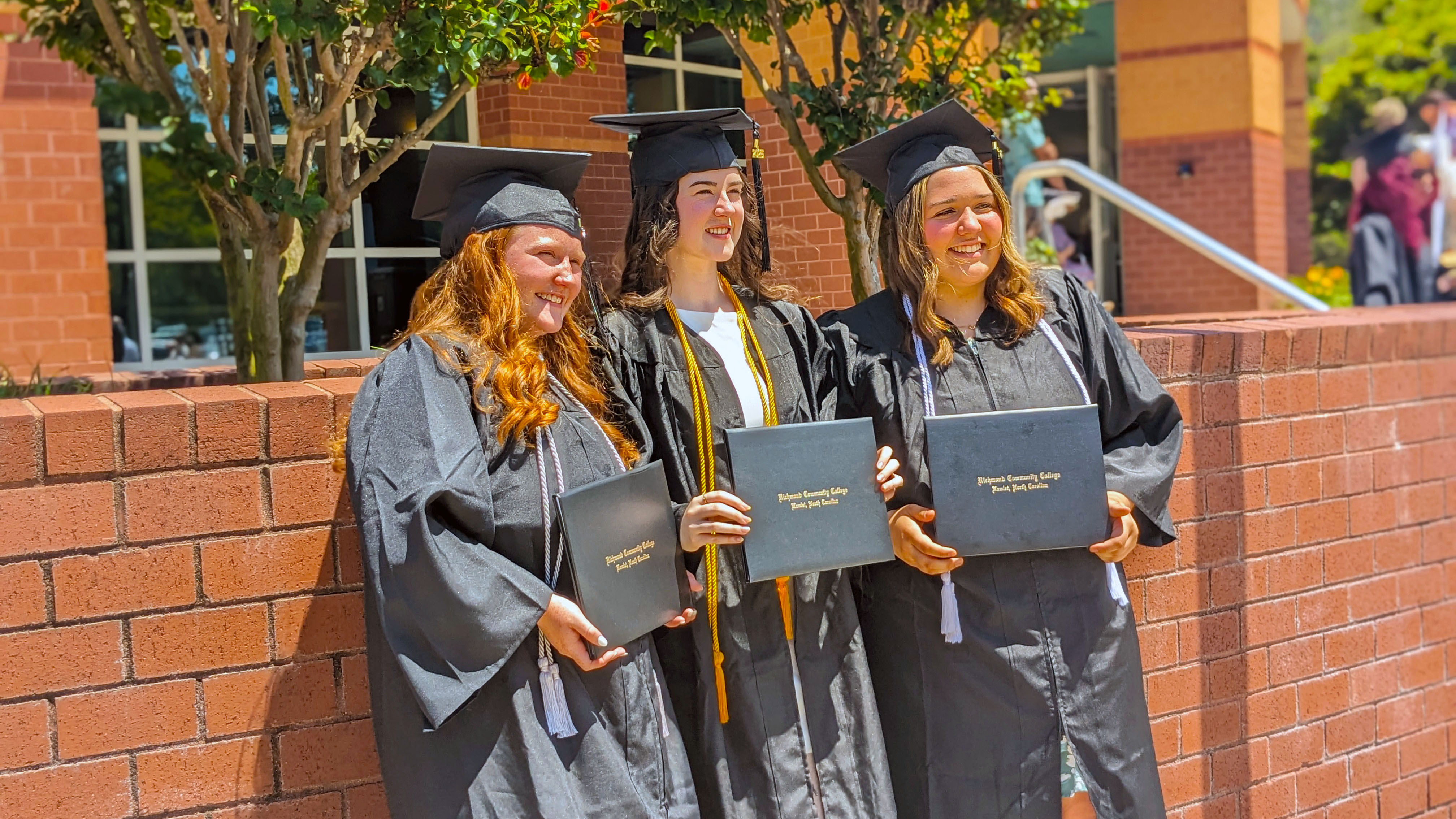 Graduates holding their diplomas