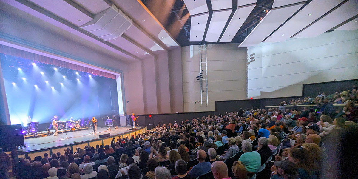 Singers on stage of the Cole Auditorium in front of an audience