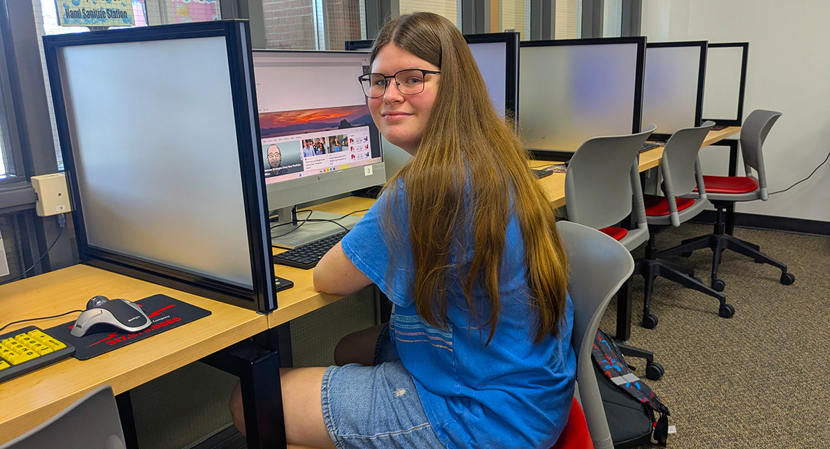 Student in the library sitting at a computer