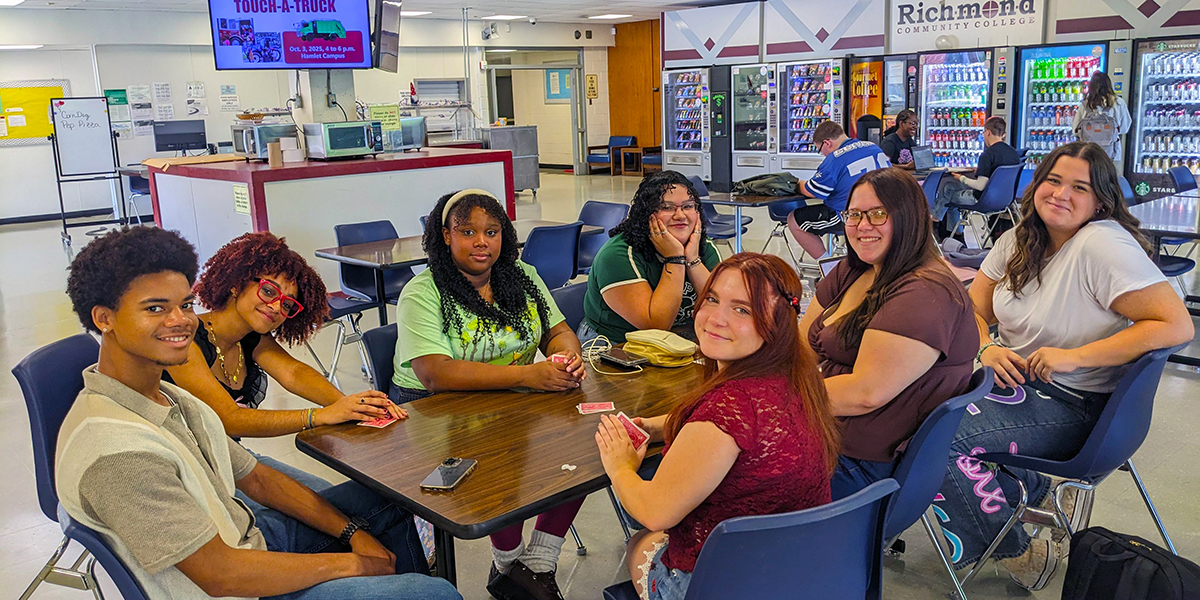 Students sitting a table in the Student Lounge area.