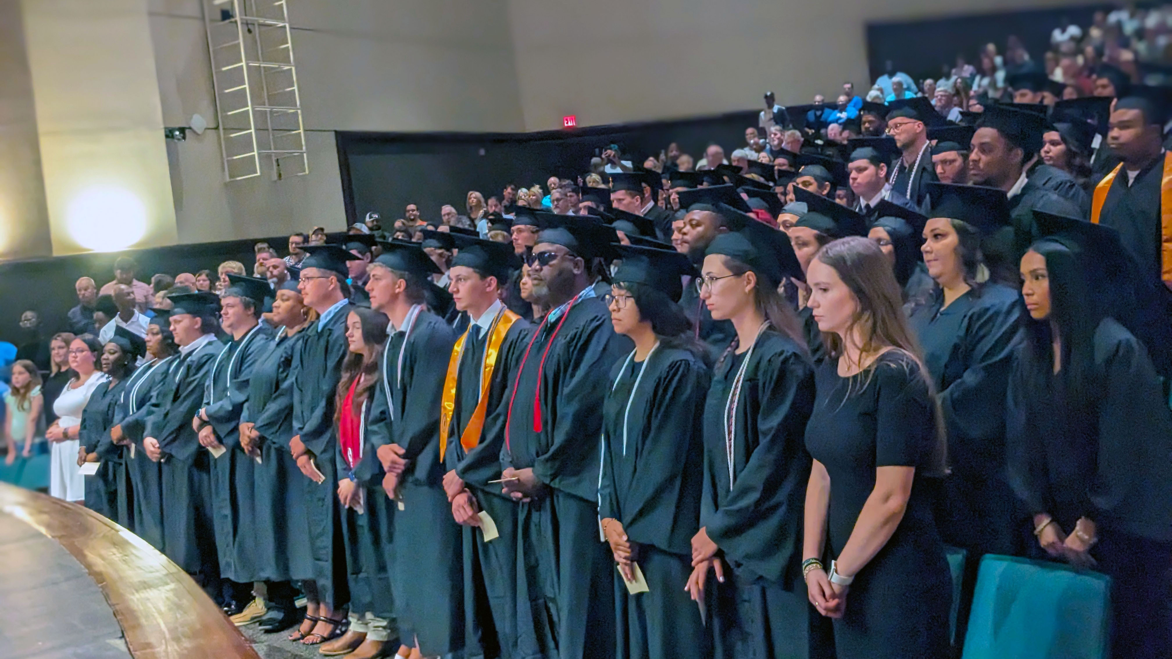 Students in graduation gowns and caps at a graduation ceremony