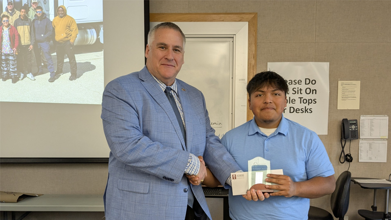 Dean presents student with a certificate.