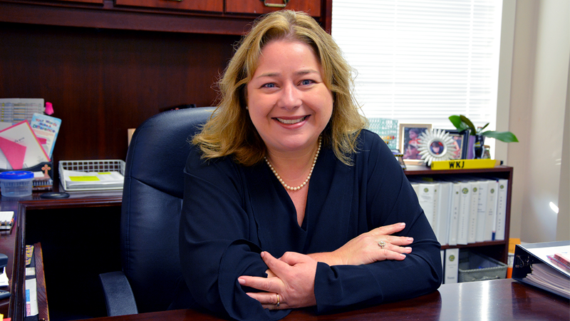 Photo of Wendy Jordan sitting at her desk in her office