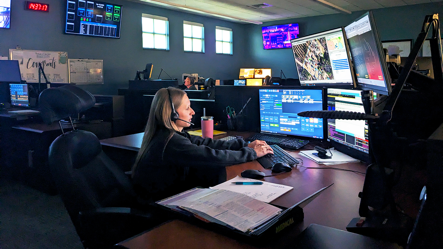 Telecommunicator sitting at work station in 911 center