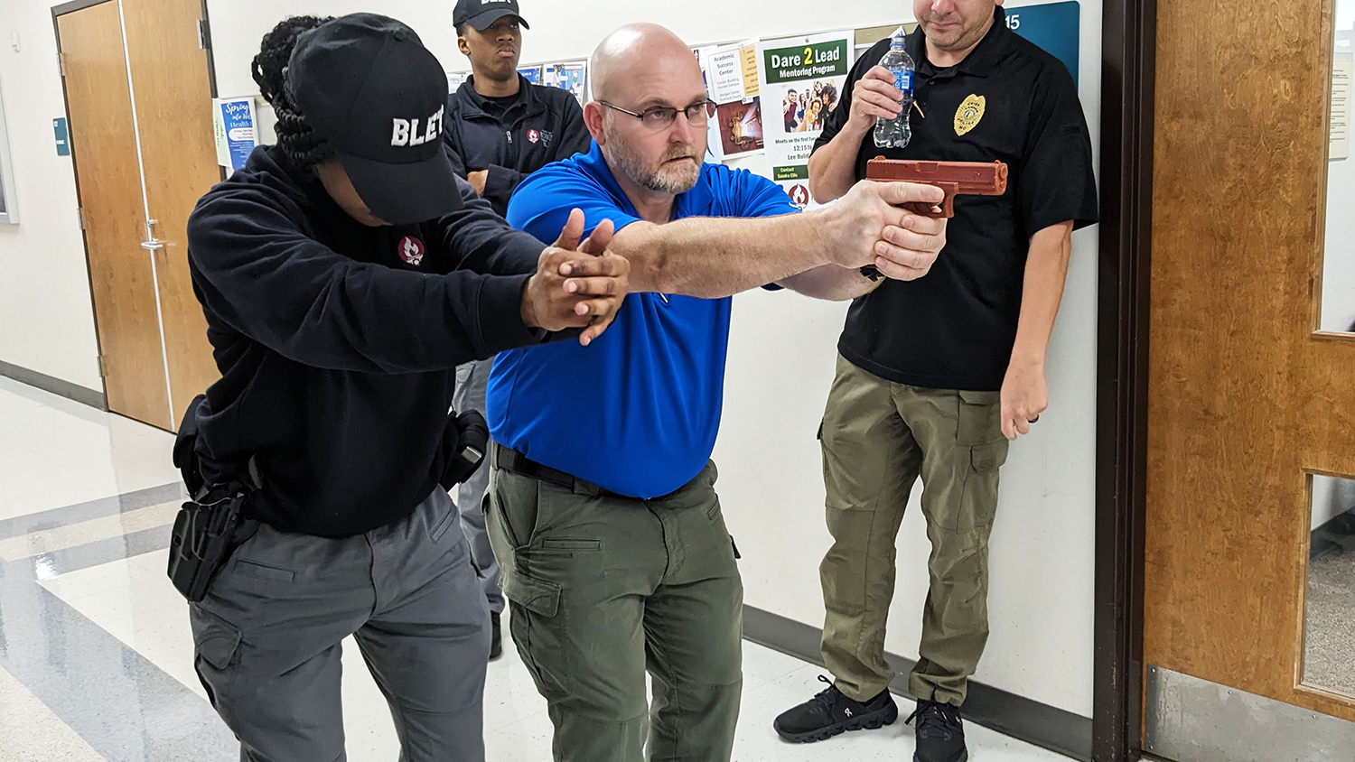 BLET instructor works with a cadet on proper gun handling