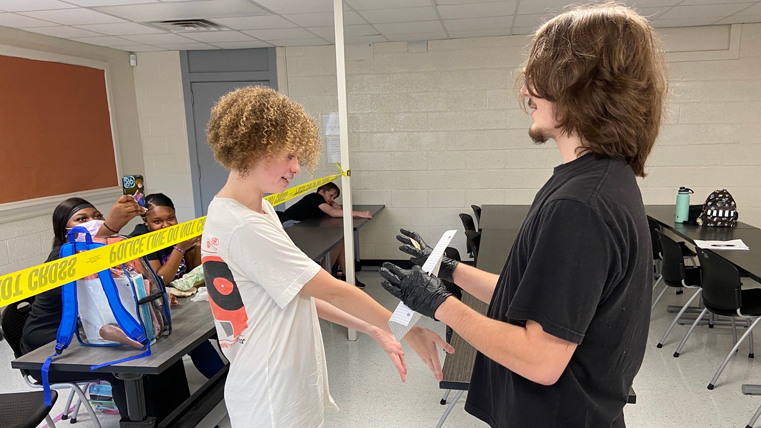 Two students participate in a mock criminal justice crime scene.