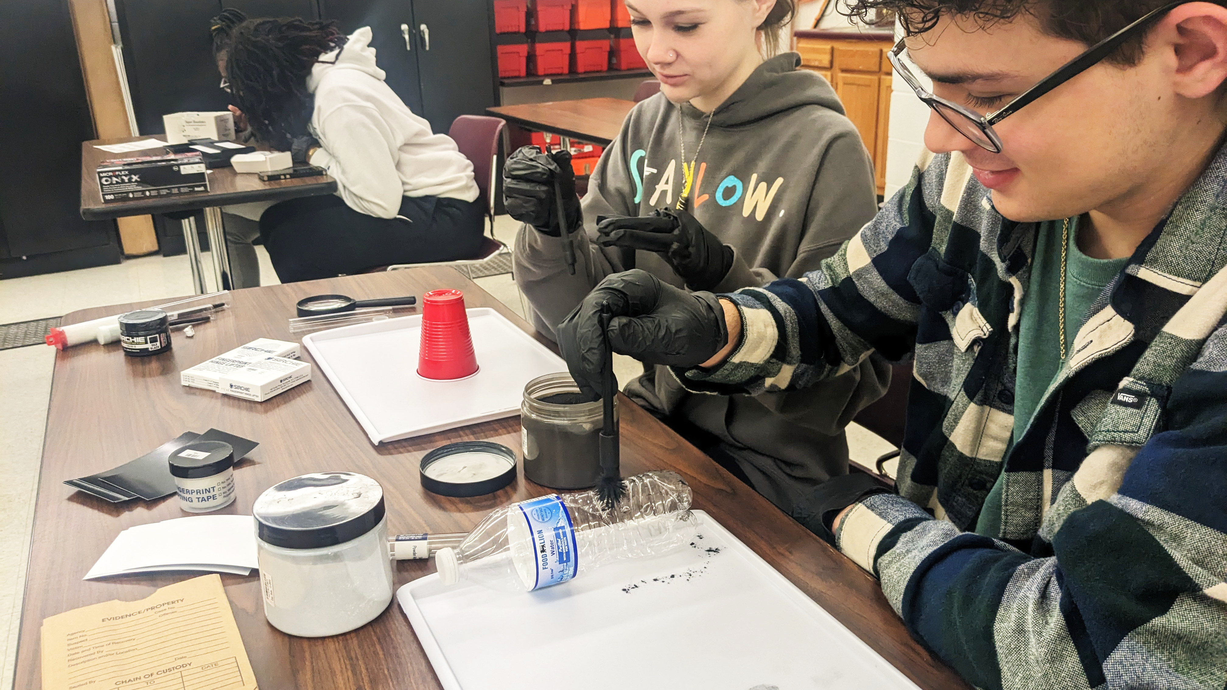 Students using fingerprinting kits at a table