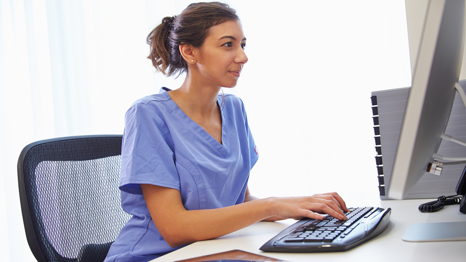 A woman sits at an office desk
