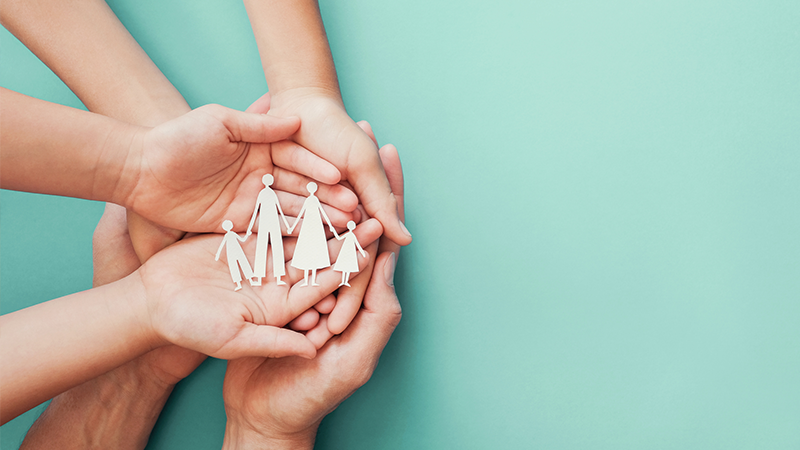 Hands holding paper cut outs of people