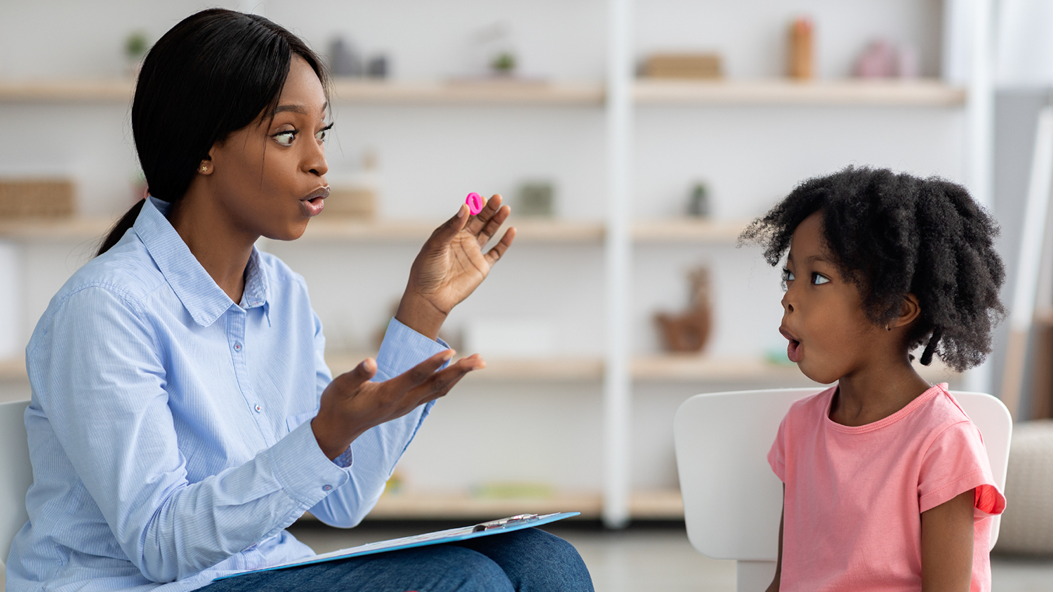 A speech pathologist helps a child with speaking