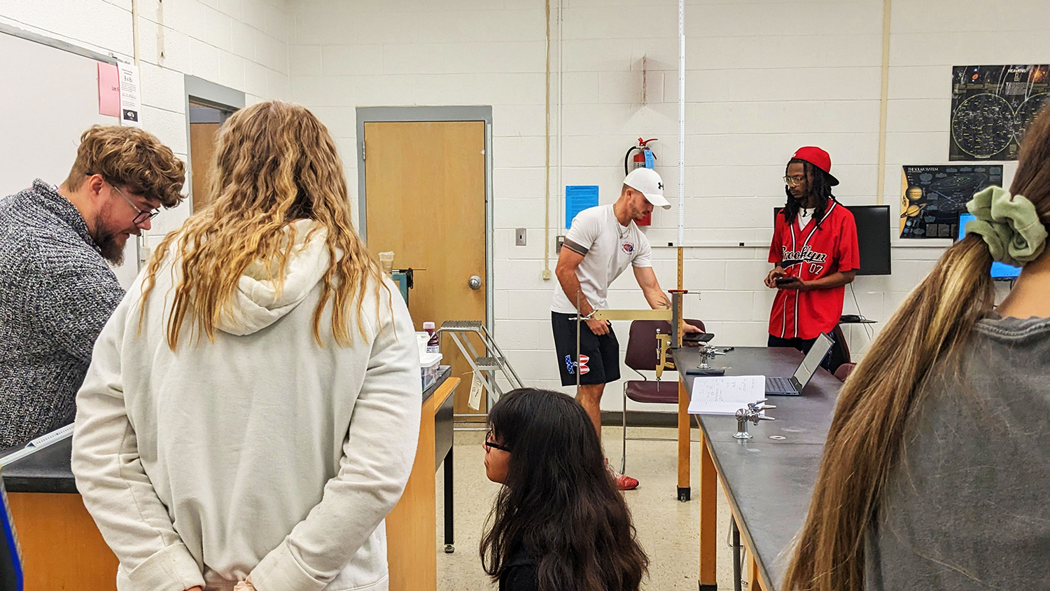 Students work on various projects with chemistry instructor guiding them.