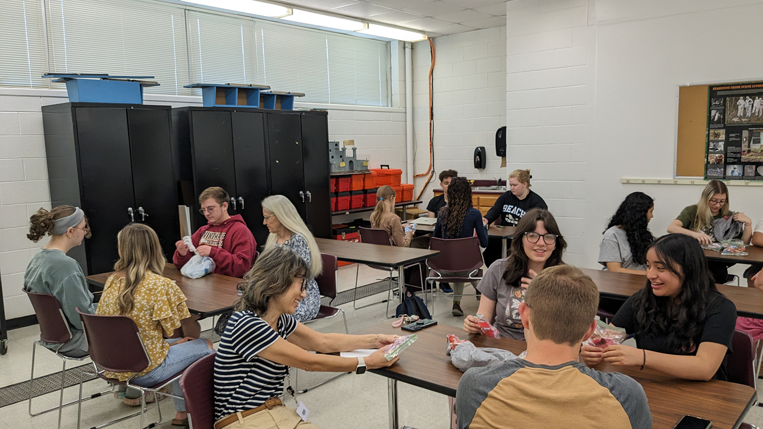 Students sit at tables while participating in a candy trade game to understand bsuiness trading.