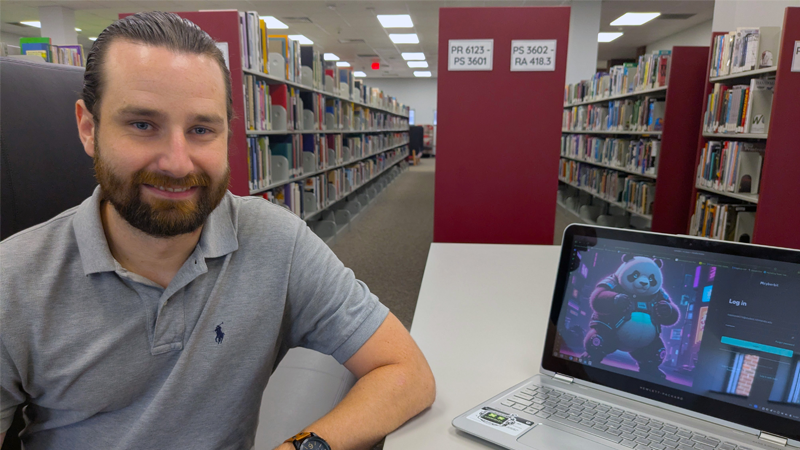 Houston Almond poses with laptop in RichmondCC Library